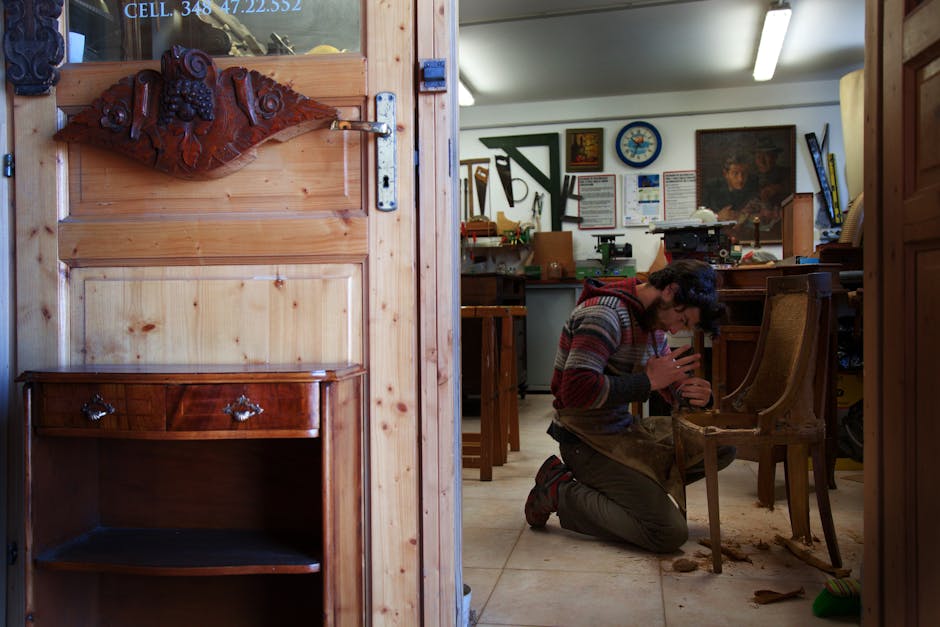 Craftsman skillfully restoring a wooden chair in his workshop. Intricate work surrounded by tools.