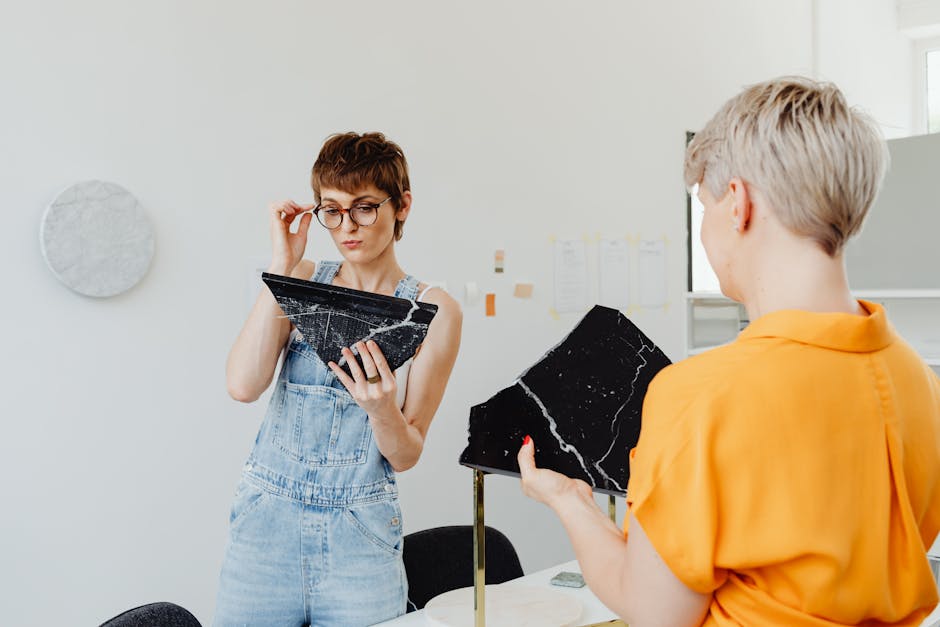 Two women working together on a marble art project, emphasizing collaboration and creativity.
